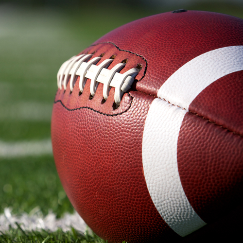 Football laying on a grass field.