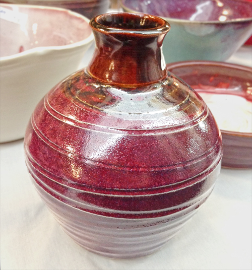 Handmade pottery vase in the colors of magenta and brown.