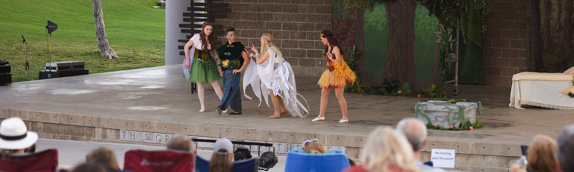 Actors performing on the outdoor amphitheater at Clement Park