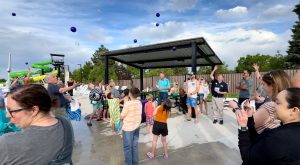 Crowd throwing balls into the air at 6th Avenue West Pool dedication