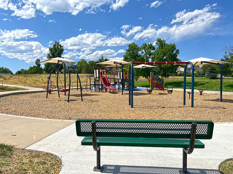 A park bench overlooking a playground.