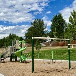 A playground with play features, slide and swings.