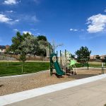 A playground with play features, slide and swings.