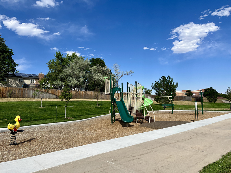 A playground with play features, slide and swings.