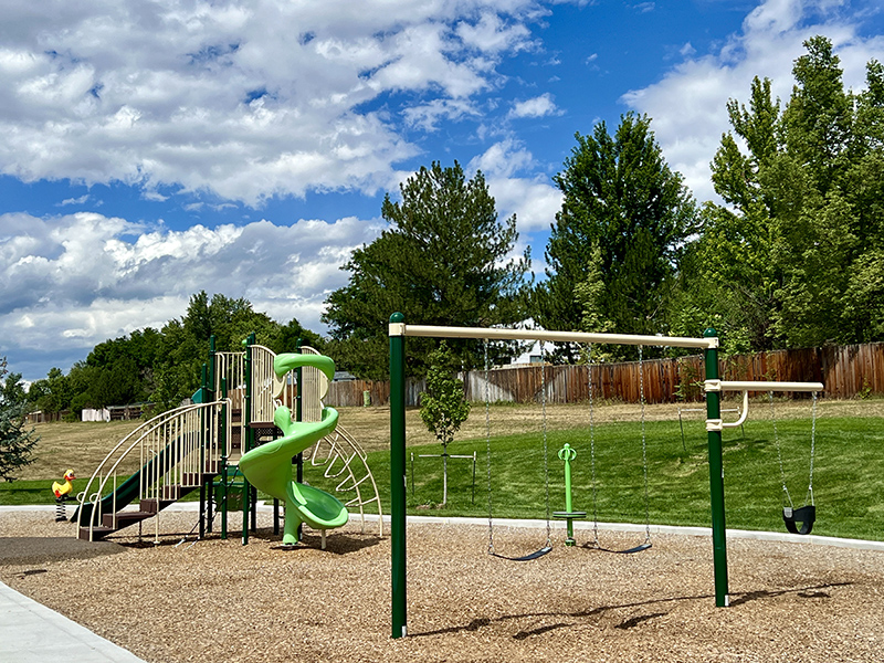 A playground with play features, slide and swings.