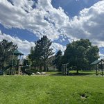 Playground with play features and a small shade structure.