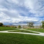 Park view with green grass and sidewalk.