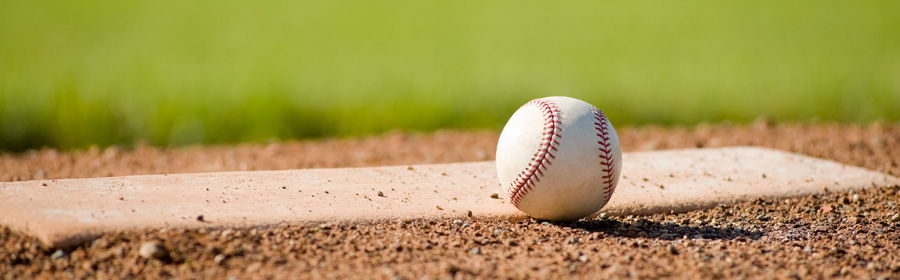 Ground view of a baseball sitting on home plate of a baseball field